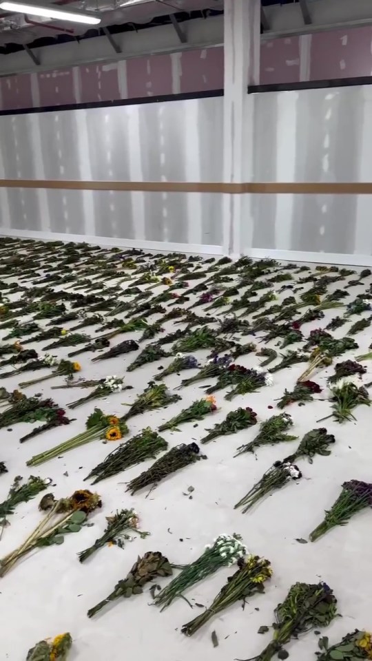 Numerous wilted flower bouquets laid on the floor.