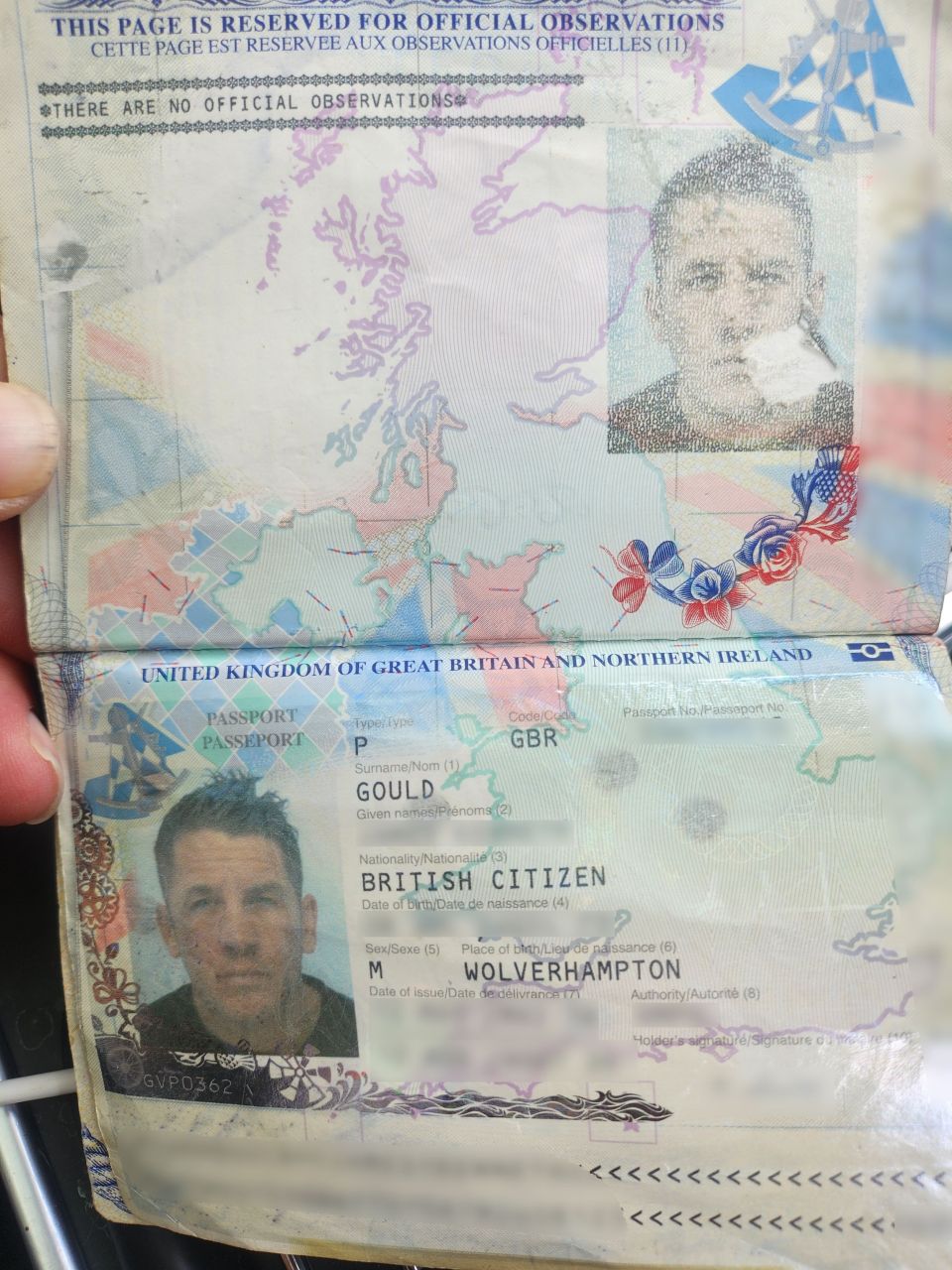 Close-up photo of a British passport with a small tear.