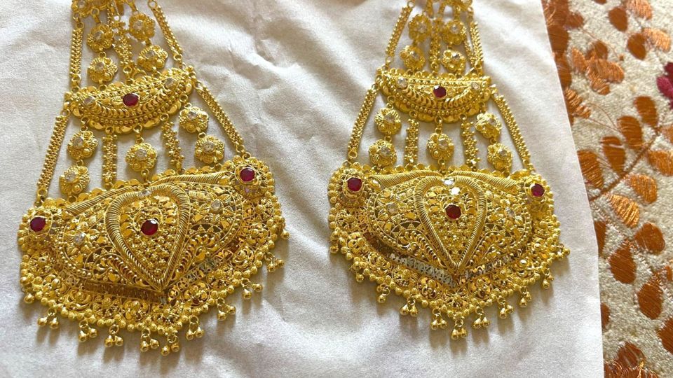 Gold earrings with red and white stones.