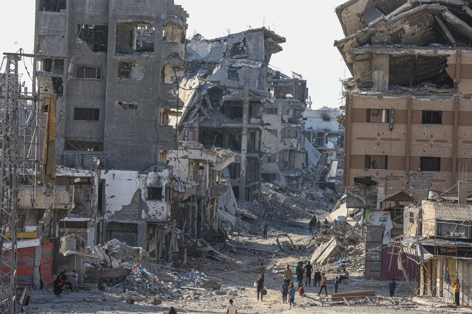 Destroyed buildings and people walking through rubble in Shujaiyya, Gaza.