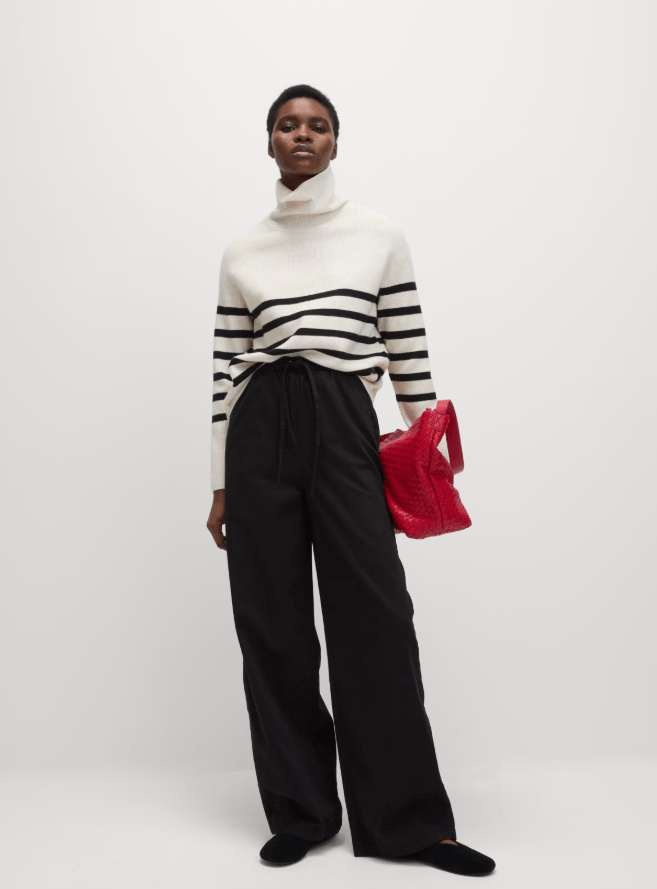 Model wearing striped sweater and wide-leg trousers.