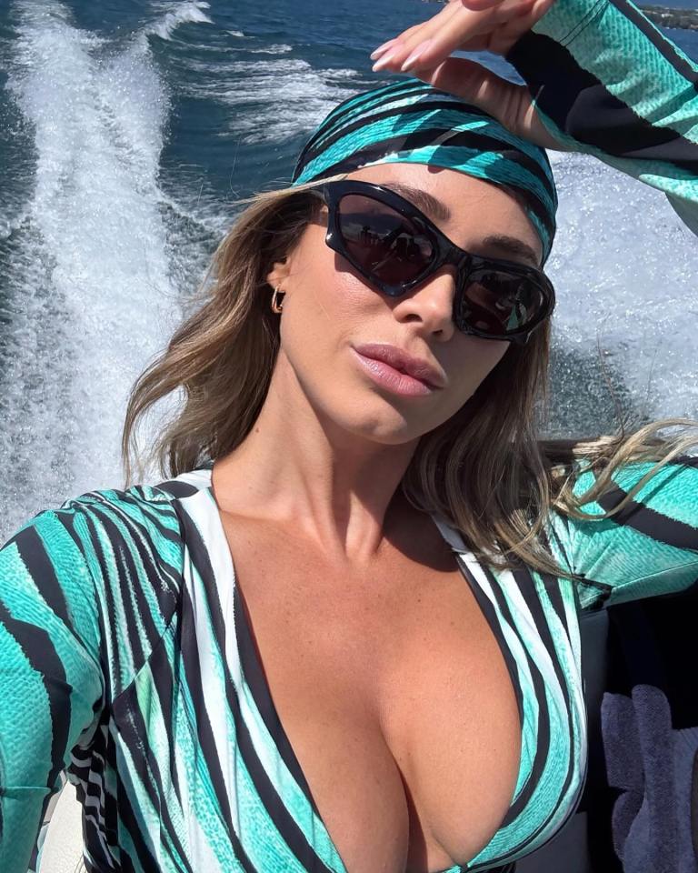 DAZN host Diletta Leotta on a boat wearing a teal and black striped swimsuit.