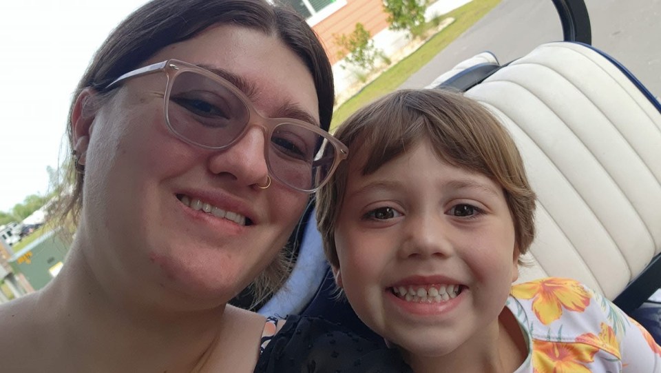 Photo of a woman and a young girl smiling for a selfie.