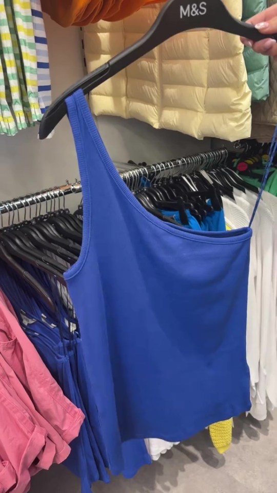 Blue one-shoulder top on a hanger in an M&S store.