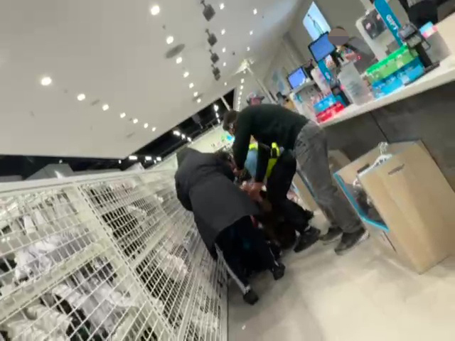 Security guards breaking up a fight between a Primark employee and a customer.