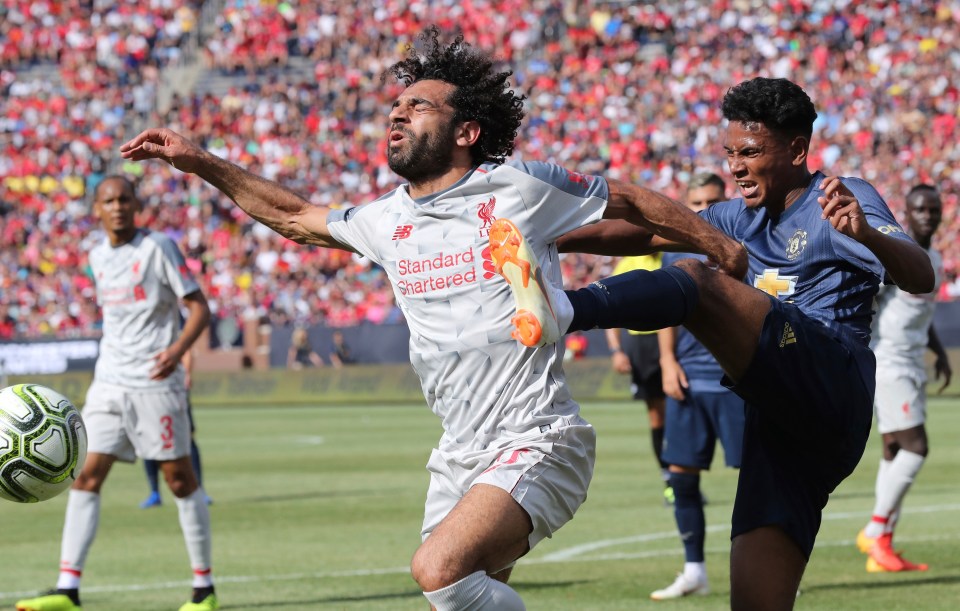 Mohamed Salah being fouled during a soccer match.