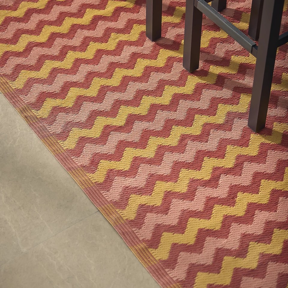 Zigzag outdoor rug in red, pink, and yellow.