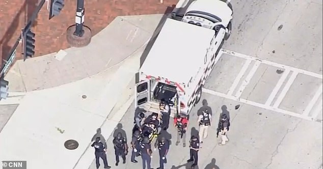 Pictured: An ambulance is seen near Emory Point, where the shooting took place. Its not clear if this is the civilian or the police officer being rushed to the hospital