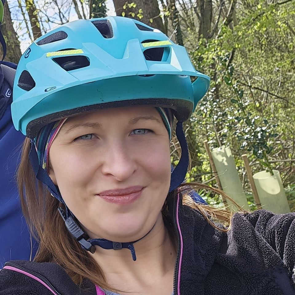 Close-up of Klaudia Mitura, a cyclist wearing a teal helmet.