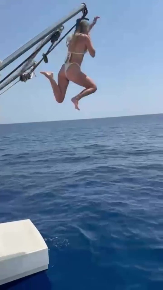 Woman jumping off a boat into the ocean.