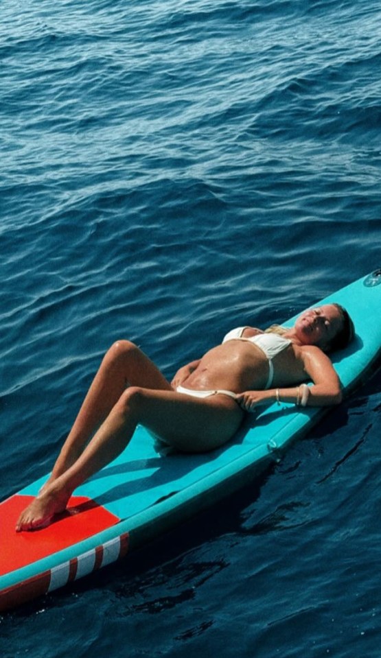 Woman sunbathing on a paddleboard.
