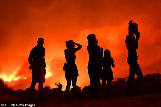Turkey, Greece, and France have also been struck by the devastating wildfires - triggered by hotter and drier conditions. Pictured:Residents look at flames as a wildfire rages near Palaia Fokaia, some 45 Km south of Athens, on August 8, 2025