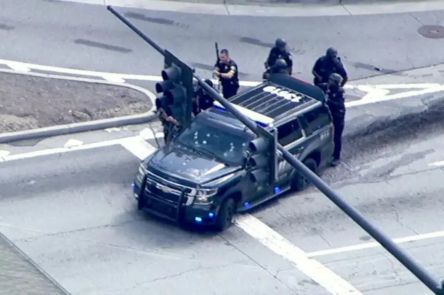 Police officers surrounding a police vehicle near Emory University.