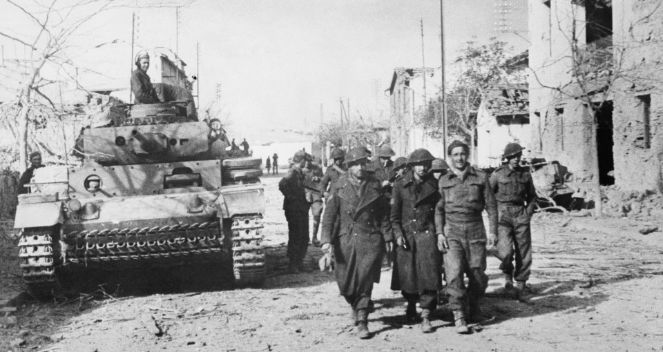 Photo of a German tank and captured British soldiers in Tebourba, Tunisia during World War II.