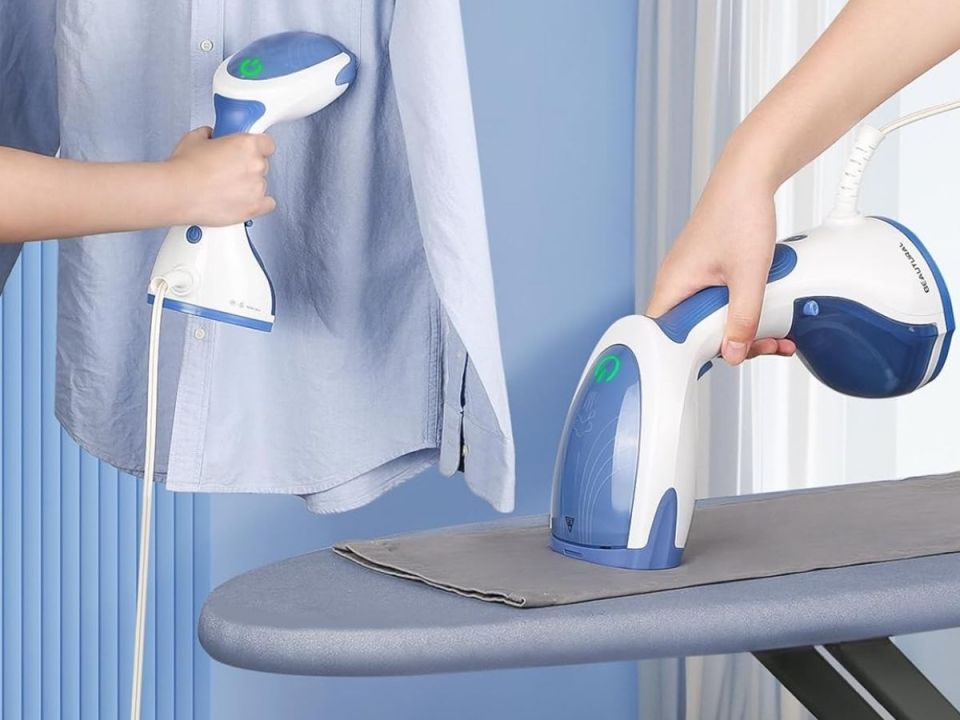 A handheld garment steamer in use.
