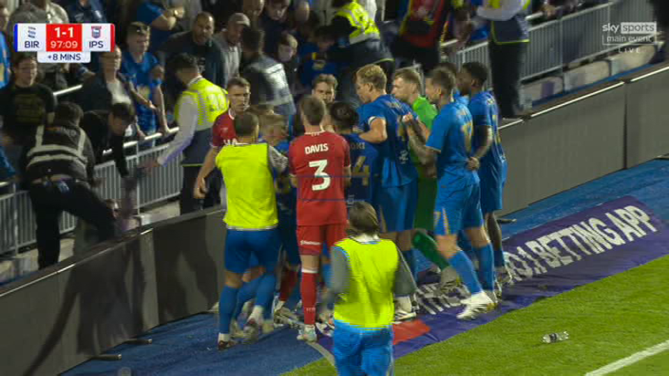 Soccer players arguing near the sidelines.