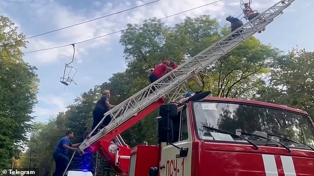 Emergency services are seen carrying out a rescue mission for those injured in yesterday's cable car horror plunge in Russia