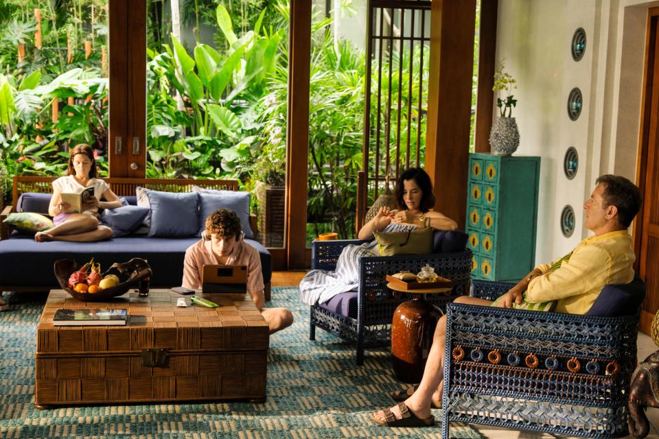 A family relaxes in a luxurious tropical home.