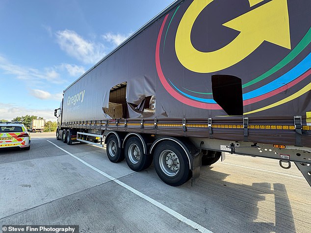 The container of a truck is left ripped open at a service station in Folkestone, Kent