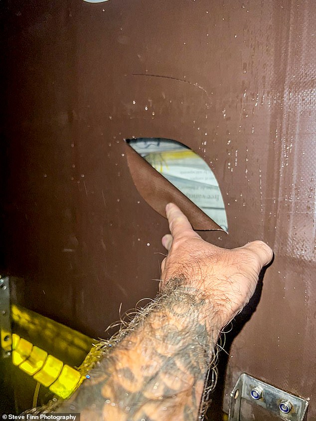 A trucker reveals the damage done to his container after thieves slashed it open while it was parked at a services in Folkestone, Kent