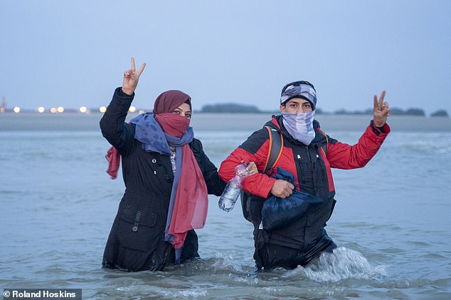 The rubber vessel was pictured off the French coast, just east of Calais, this morning, before heading off into the English Channel. Some passengers threw peace signs at the camera (pictured)
