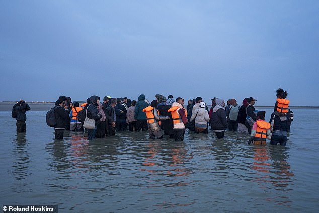 They soon wade into the water at around knee depth as they wait for boats to arrive (pictured)