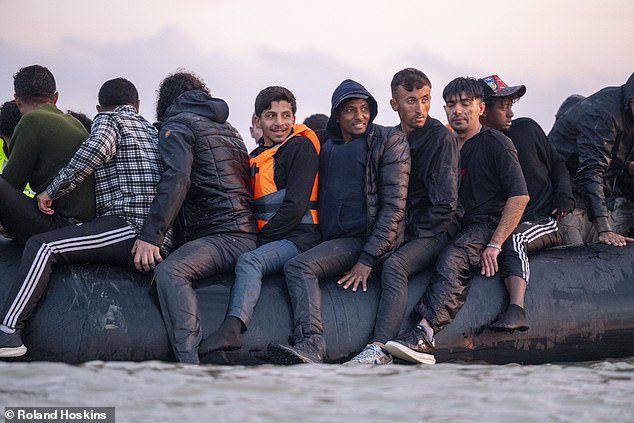 A row of young men can be seen sitting astride the edge of the vessel (pictured)