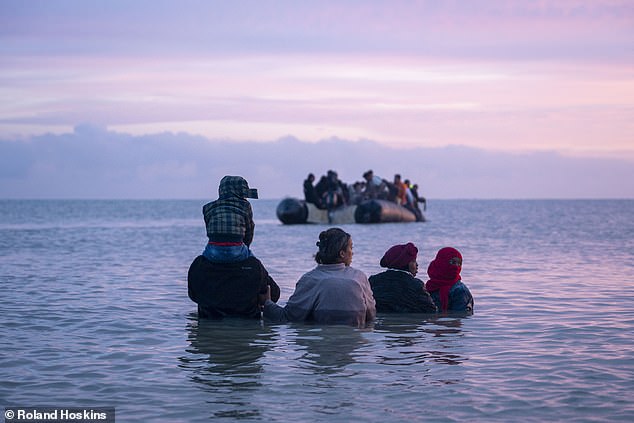 After the first boat is loaded up, remaining passengers watch on as it embarks on its journey into the Channel (pictured)