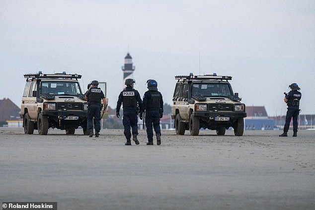 Two French gendarmerie vehicles can be seen on the sand (pictured)