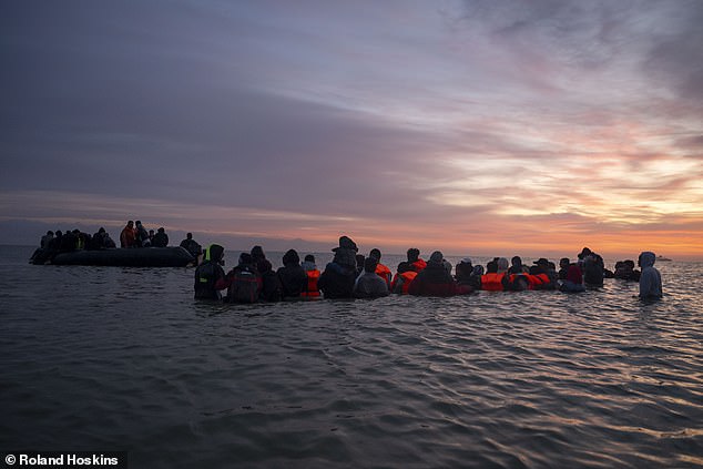 She added: 'Criminal gangs have spent seven years embedding themselves along our border and it will take time to unravel them'. Pictured: Migrants waiting for a boat at Gravelines beach today