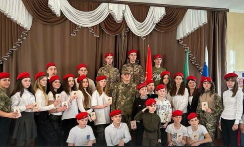 Group of children and adults wearing red berets.