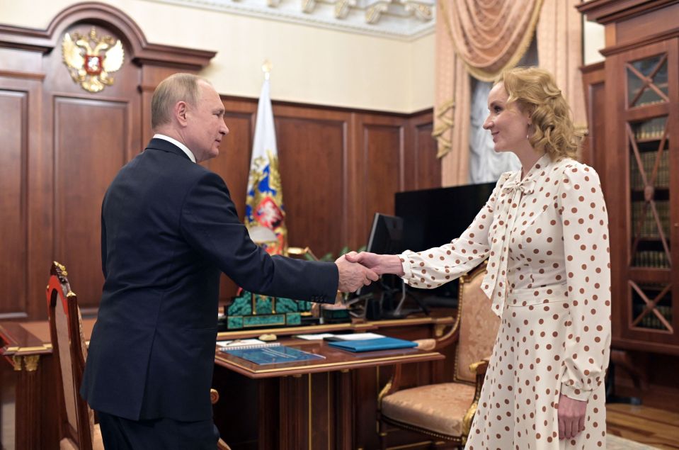 Vladimir Putin shaking hands with Maria Lvova-Belova.
