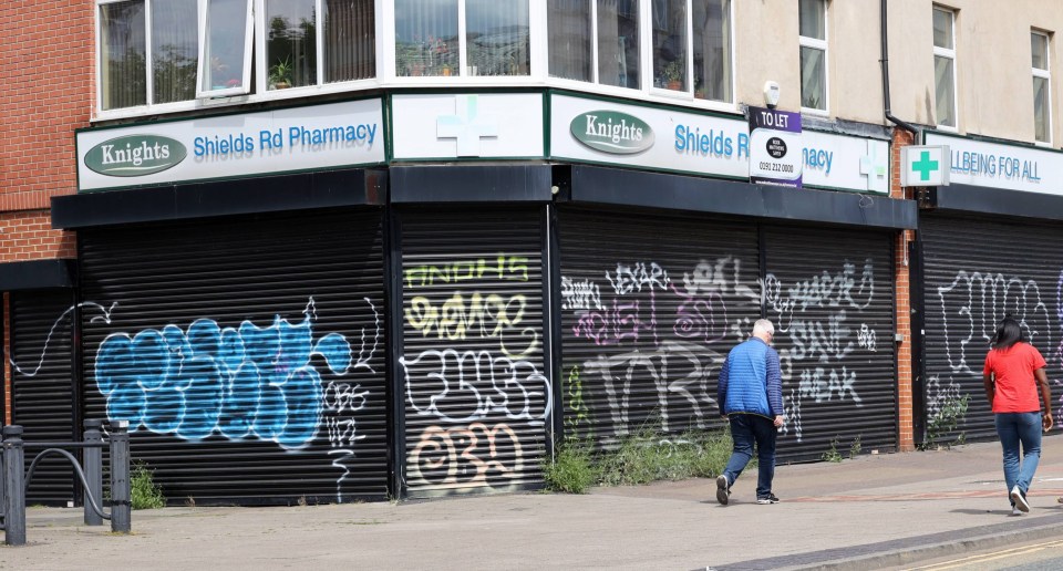 Graffiti-covered closed shops on Shields Road, Newcastle.