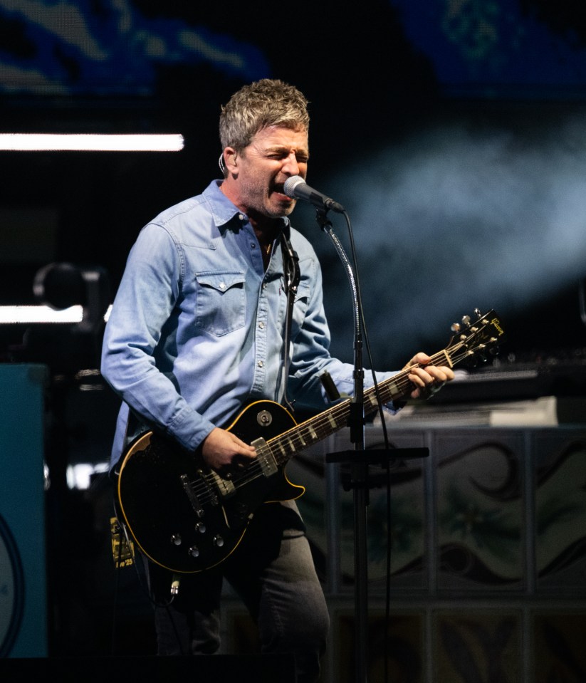 Noel Gallagher of Oasis performing on stage.