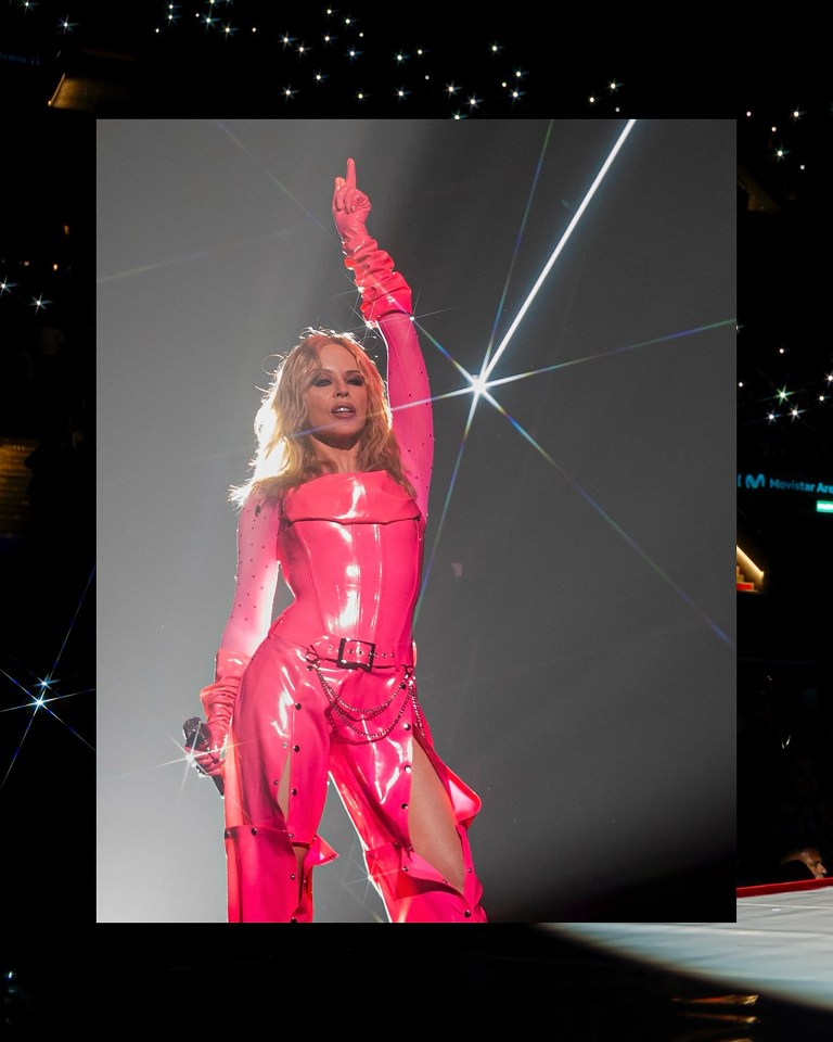 Kylie Minogue performing on stage in a pink outfit.