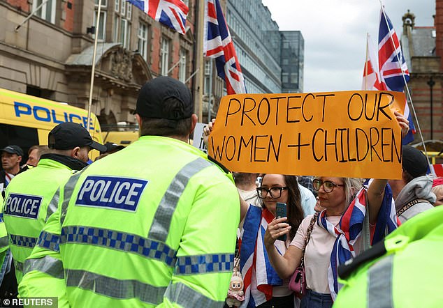 Police officers stand guard as anti-immigration protesters gather in Liverpool, Britain, August 9, 2025