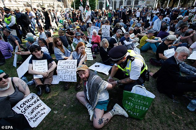 The protest began at 1pm today when hundreds of activists sat down and silently held the illegal placards