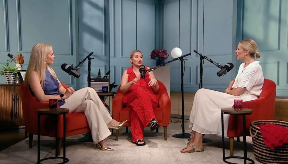 Three women sitting in red chairs during a podcast recording.