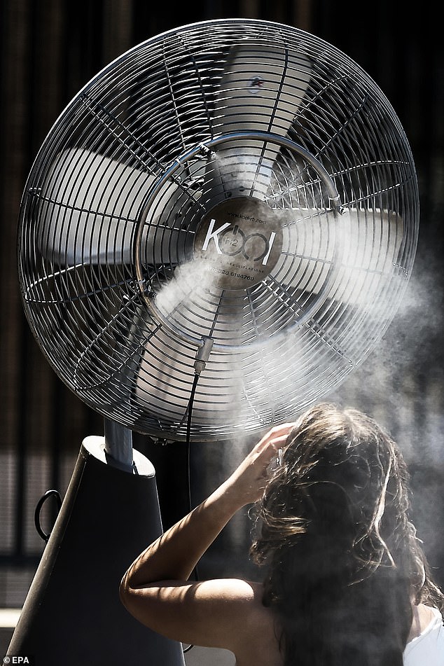 A woman seeks refreshment at the Colosseum on a hot day in Rome, Italy, 8 August 2025