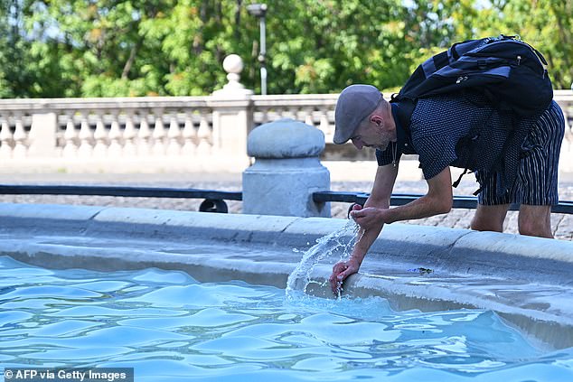 A man cools off at the Acqua Paola Fountain ("Fontanone") on Gianicolo Hill in Rome, on August 9, 2025