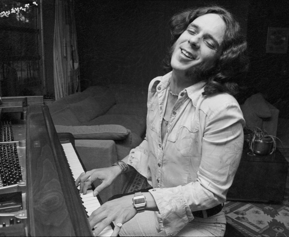 Black and white photo of Bobby Whitlock playing piano.