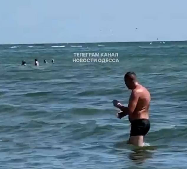 People in the sea in the aftermath of the devastating blasts, which took place this morning