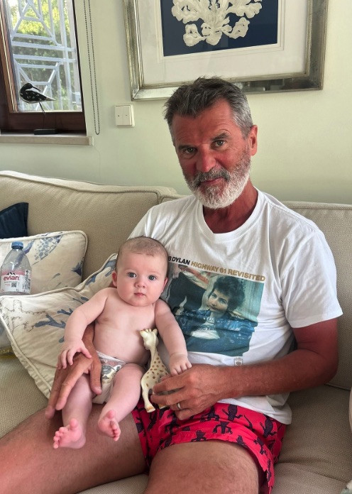 Roy Keane holding a baby.