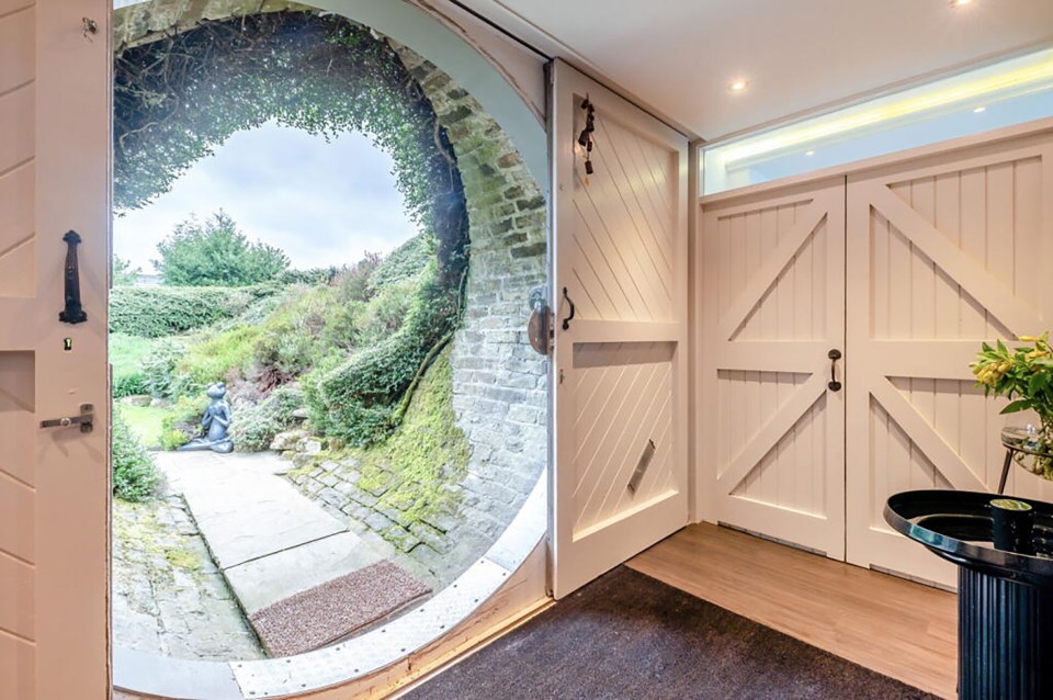 Interior view of a home's entrance featuring a circular doorway with a garden view.