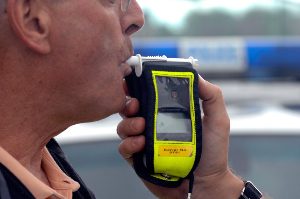 Man blowing into a breathalyzer.