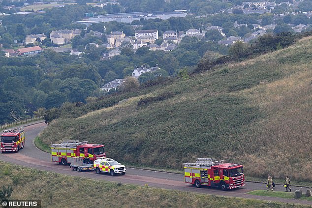Firefighters work at the scene as a wildfire burns at Arthur's Seat in Edinburgh