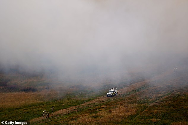 Thick smoke seen overhead as a fire service vehicle arrives at the scene in Holyrood Park