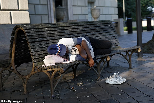 A person sleeps on a bench on July 25 in Washington, DC. President Trump signed an executive order making it easier for cities and states to remove homeless people from the street