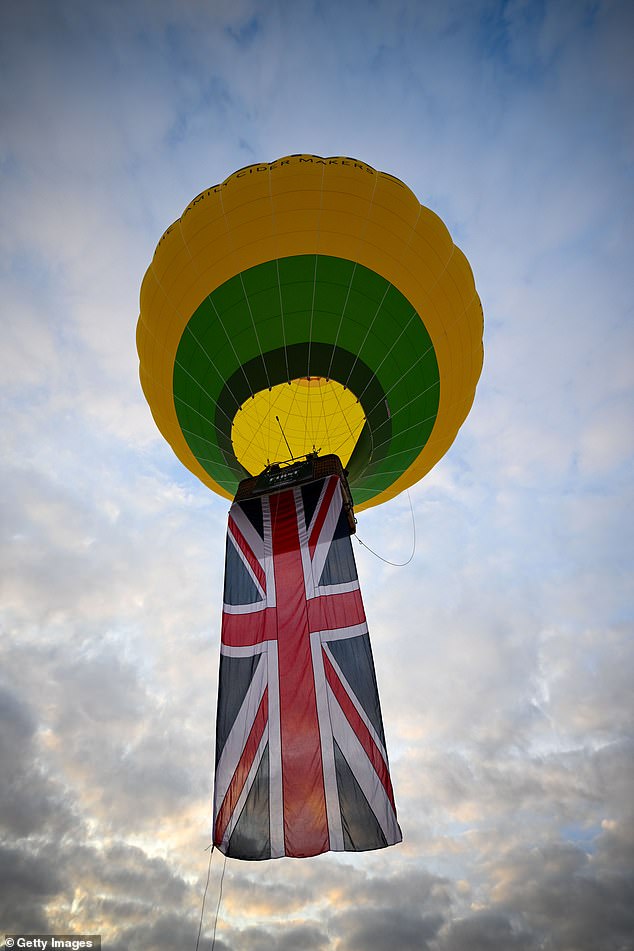 A yellow and green balloon with a Union Jack flag hanging out of it