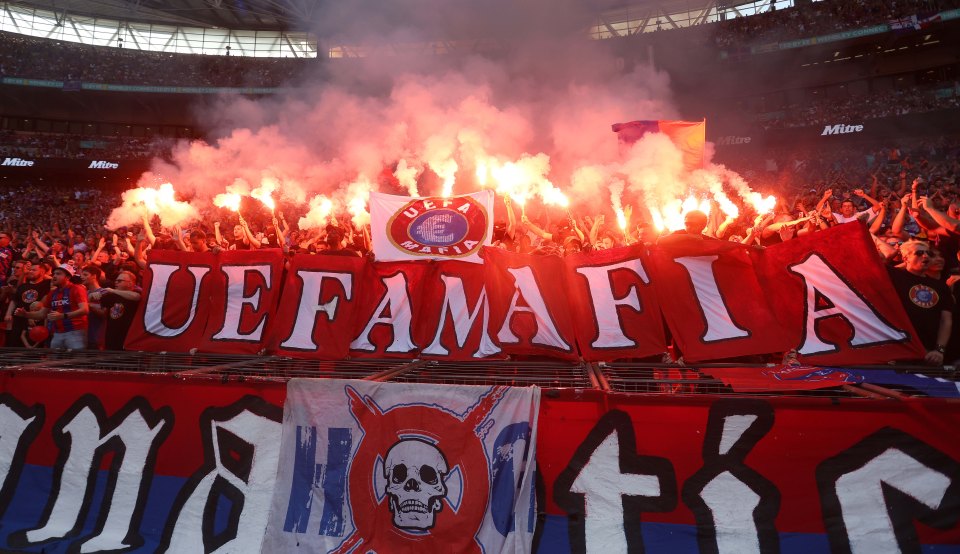 Crystal Palace fans protesting UEFA, holding flares and a banner reading "UEFA Mafia".